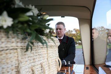 pallbearer putting coffin inside the fleet